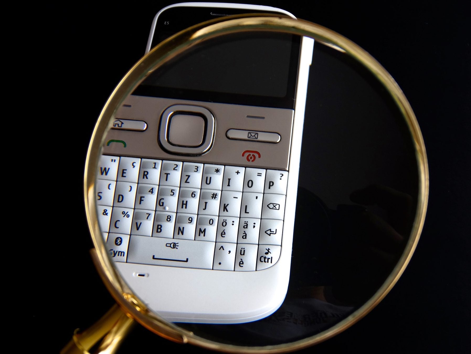A magnifying glass hovers over a Blackberry in an image illustrating a story about Liberty and the NUJ securing a change to the Snoopers' Charter which will require intelligence agencies to receive independent approval before they can search for or retain journalistic material in bulk hacked data.
