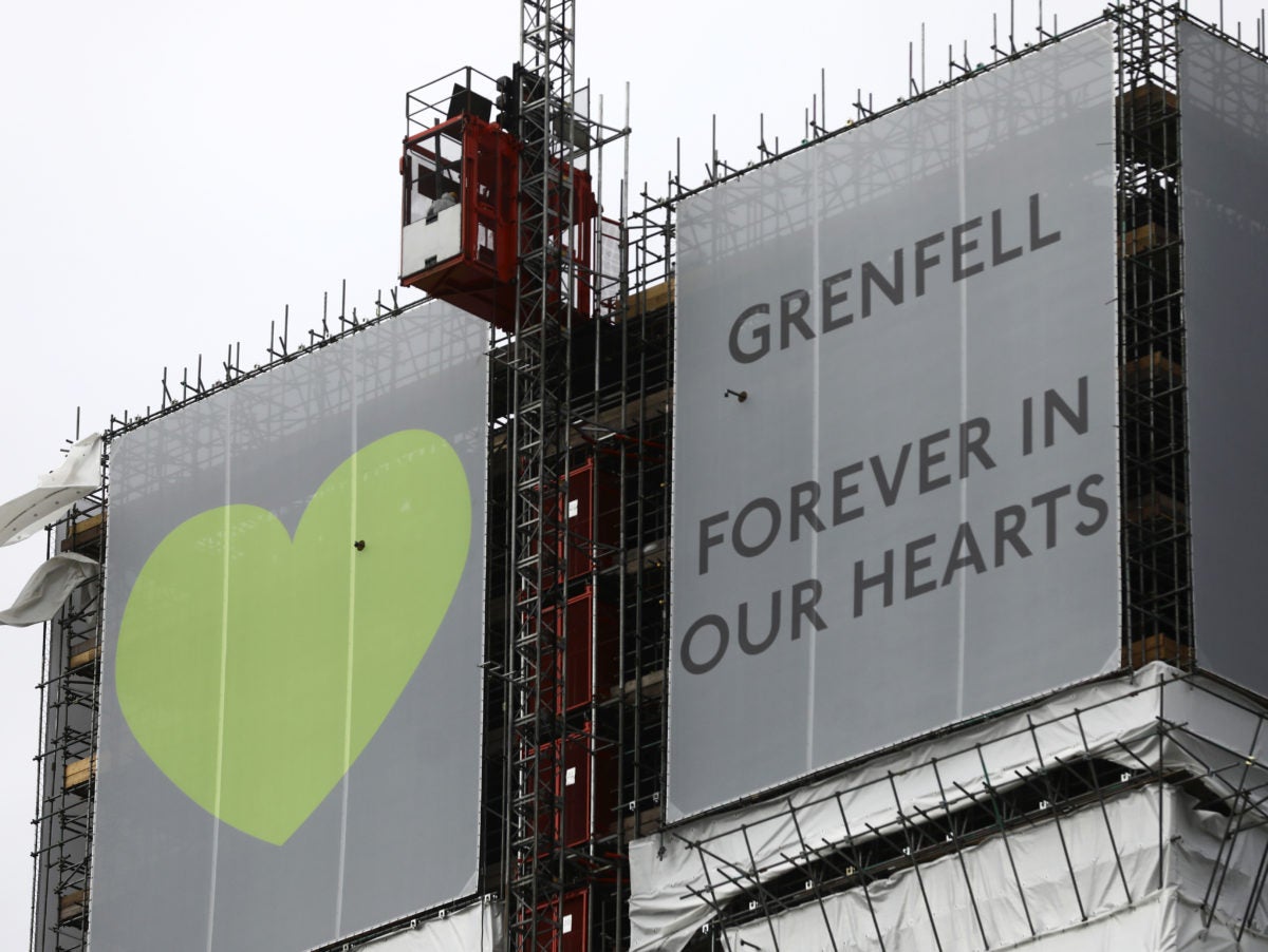 Hoarding at top of Grenfell Tower saying 'Grenfell forever in our hearts' with a big green heart