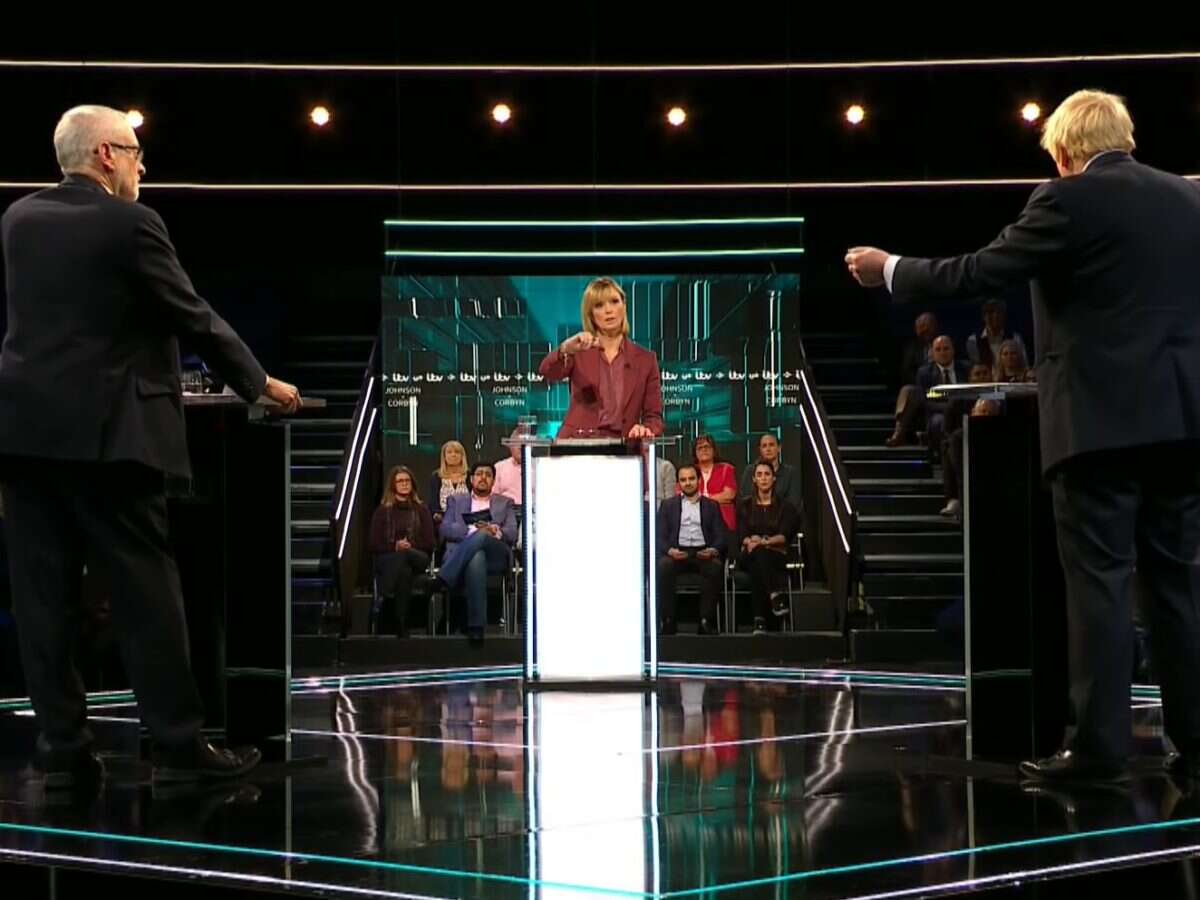 Julie Etchingham in a TV studio moderating a debate between Boris Johnson and Jeremy Corbyn