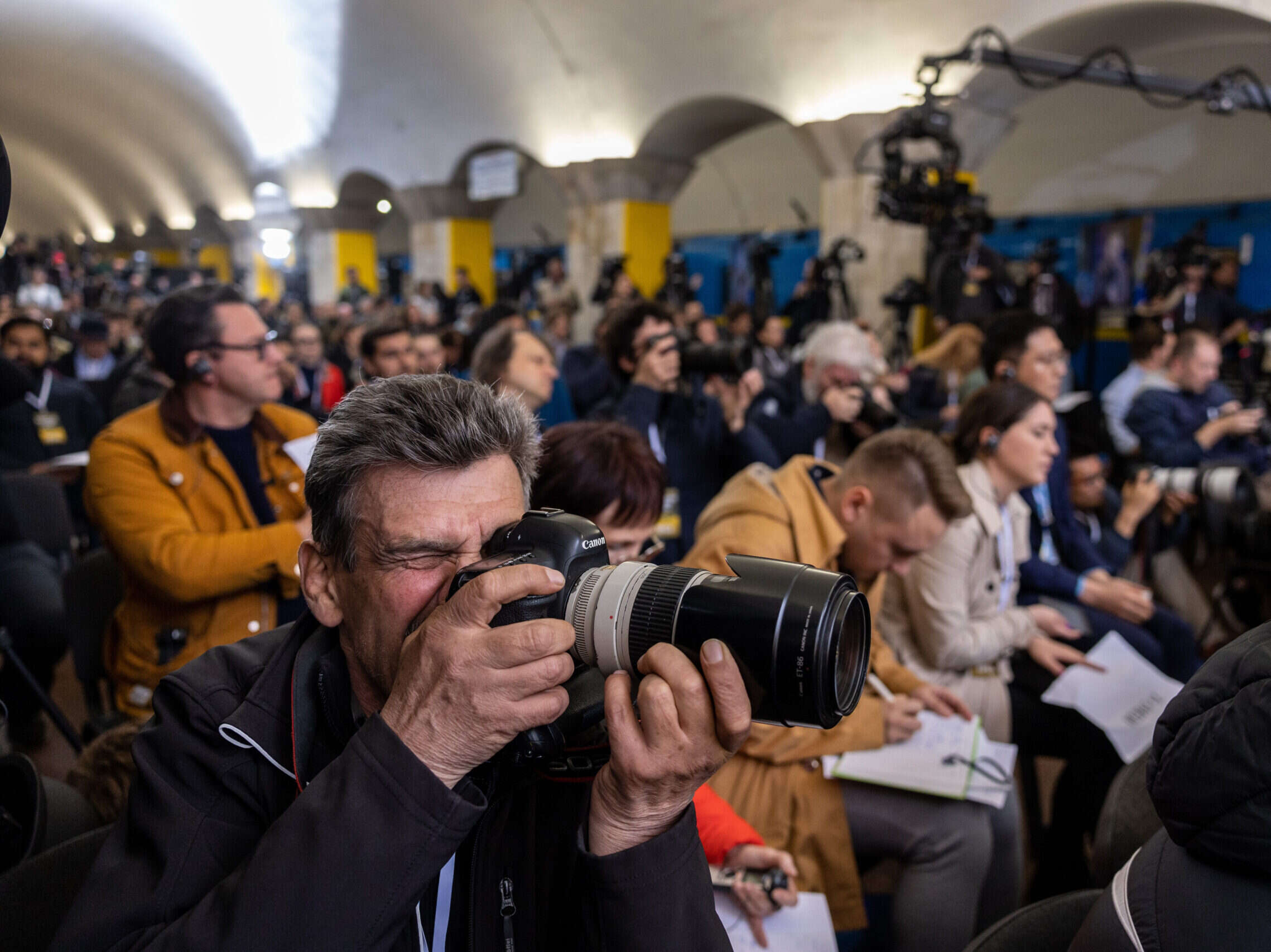 Ukraine double standards - a photographer in Ukraine takes a picture from within a large press pack