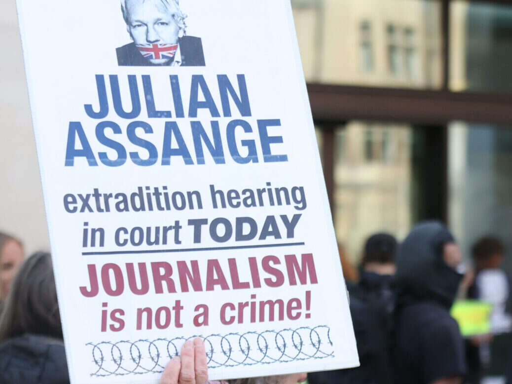 Julian Assange sign outside court