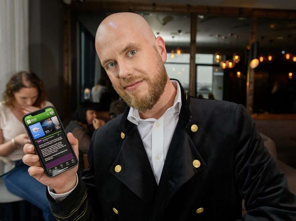 Mylocal's Daniel Ionescu, who is also the managing editor of The Lincolnite, holds a phone displaying the Mylocal app