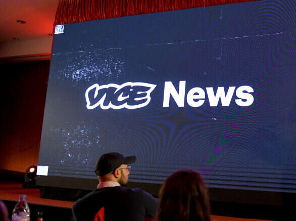 The Vice News logo is projected onto a screen, illustrating a story about the shuttering of Vice.com and the laying off of hundreds of Vice staff.