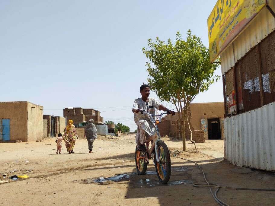 A youth rides a bicycle on a street in Omdurman's al-Thawrat area on July 16, 2023, as fighting continues in war-torn Sudan. Photo: AFP via Getty Images