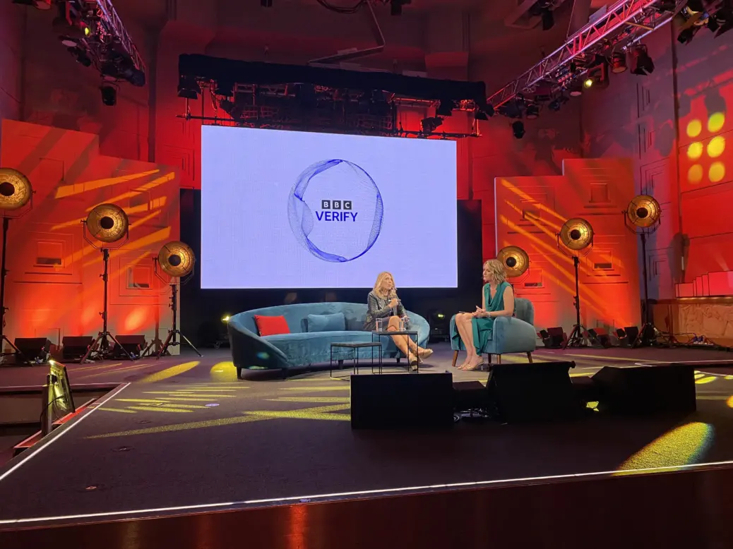 BBC News chief executive Deborah Turness speaks to BBC News chief presenter Lucy Hoskins in front of a screen displaying BBC Verify branding. Picture: Press Gazette