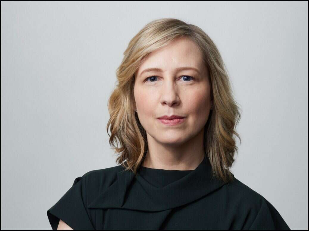 Kathleen Kingsbury, opinion editor at The New York Times, is seen in a headshot in a dark green outfit looking to camera.