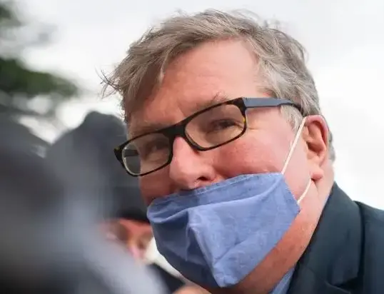 Crispin Odey pictured close up wearing glasses and a face mask