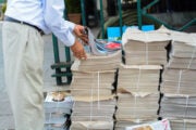 A bundle of newspapers sits on the street ready for delivery, illustrating an article about the biggest English-language news sites in the world.