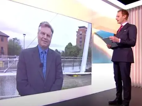 5 News presenter Dan Walker in the studio talks to political editor Andy Bell beamed live onto a screen on the wall