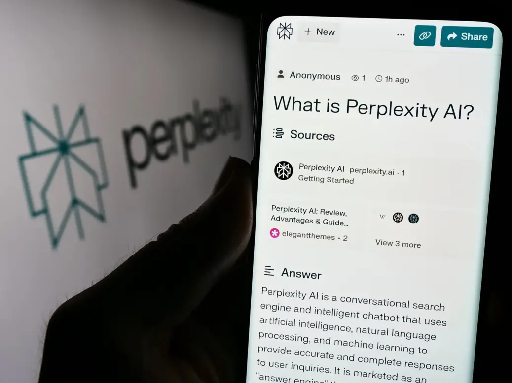 Person holding smartphone with webpage of US artificial intelligence company Perplexity AI in front of logo. Focus on centre of phone display.