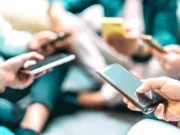 Five people holding phones in a circle - photo focused on their hands and the phones