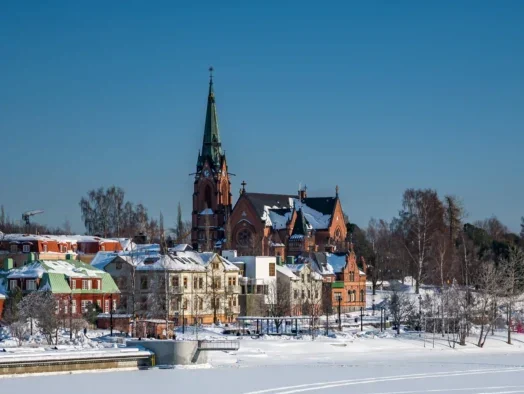 The city church of Umeå, Sweden is seen alongside the frozen Ume River in 2018, illustrating a story about VK Media, a publisher based in the city which has used its Article Horn predictive analysis tool to drive advertising and reader revenue growth from Google Discover.