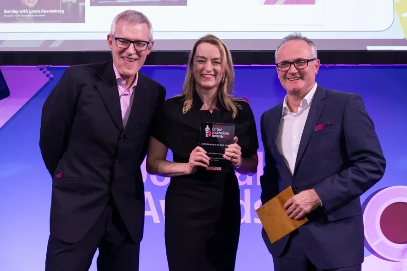 Laura Kuenssberg picks up the Interviewer of the Year award from Jeremy Vine and judge Rob McGibbon at the British Journalism Awards 2024. Picture: ASV Photography/Press Gazette