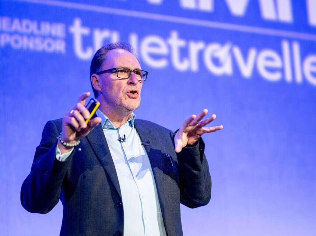 Graham Lovelance standing on a stage gesturing as he gives a speech about AI.