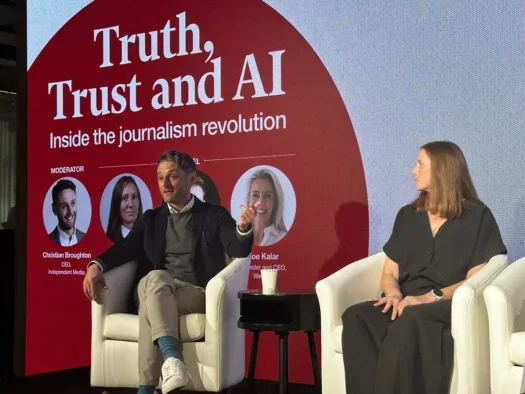 Independent Media chief executive Christian Broughton (left, dressed smart casual in a blazer) and Independent UK editor Chloe Hubbard (right, in a black dress) appear on stage at Advertising Week in London in 2025, where they talked about the brand's new AI-written news summary service, Bulletin.