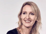 Ella Dolphin, DC Thomson's newly-appointed deputy chief executive, appears smiling and looking slightly off camera against a white background. She is wearing a dark navy dress and has long blonde hair.