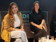 Eliza co-founders Joanna Bridger and Hannah Blake at the PPA Festival 2025 sitting side by side on stage and smiling at the camera