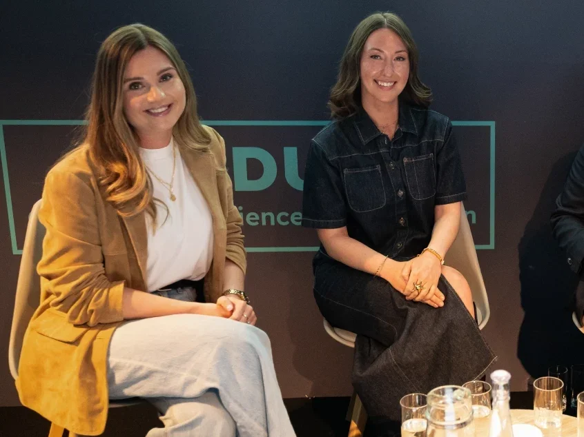 Eliza co-founders Joanna Bridger and Hannah Blake at the PPA Festival 2025 sitting side by side on stage and smiling at the camera