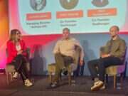 Youtube UK managing director Alison Lomax interviews Tony Pastor and Jack Davenport of Goalhanger on stage at The Podcast Show in London in May 2025. They are sitting side by side on stage with a slide showing their headshots and names behind them