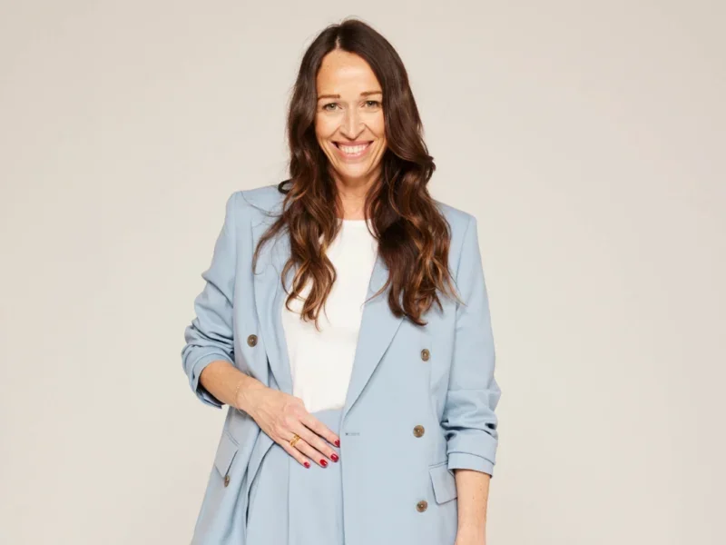 Stylist editorial director Lisa Smosarski dressed in a pale blue suit with white t-shirt and one hand on her hip