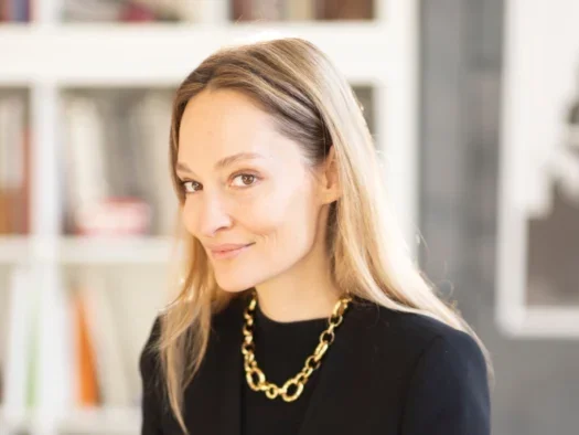 Andrea Latten, Conde Nast chief business officer for the UK, smiling at camera wearing black top and jacket and gold necklace