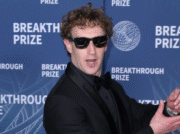 Mark Zuckerberg making a face at camera wearing sunglasses, on red carpet logo backdrop