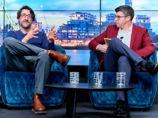 Future's Simon Collis and Beehiiv's J.T. Levin sitting on stage with London river backdrop superimposed behind