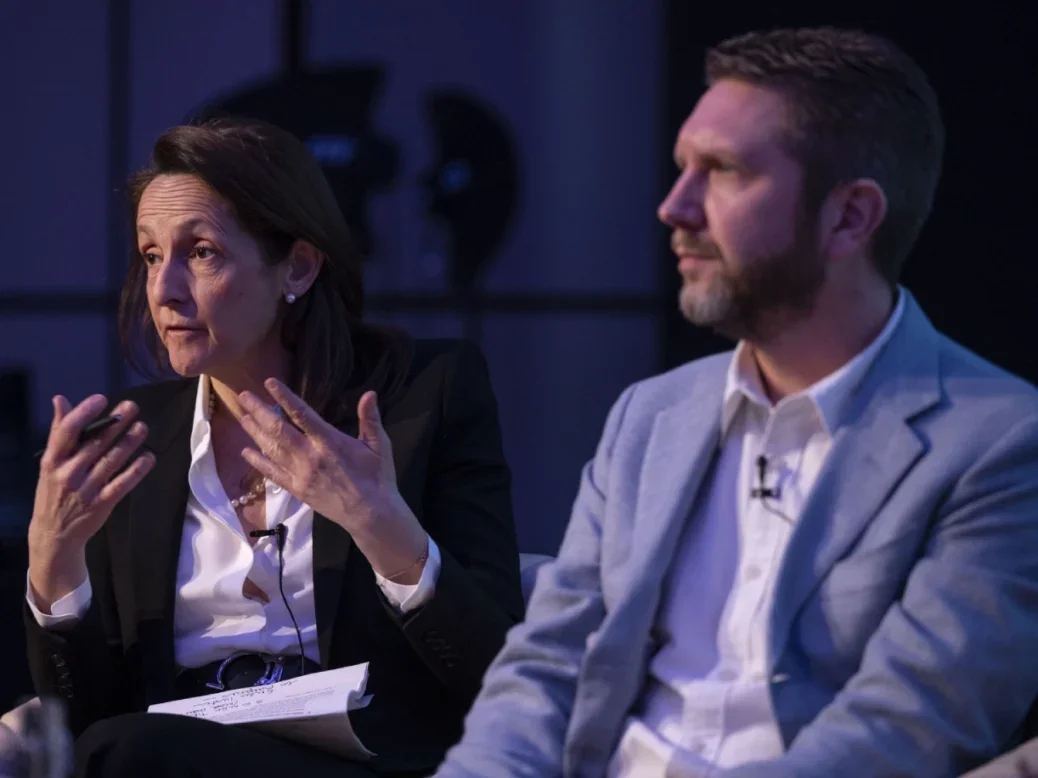 Alessandra Galloni, editor-in-chief of Reuters, and Jack Lefley, editor-in-chief of PA Media side by side on stage, Galloni is speaking and gesturing and Lefley is listening