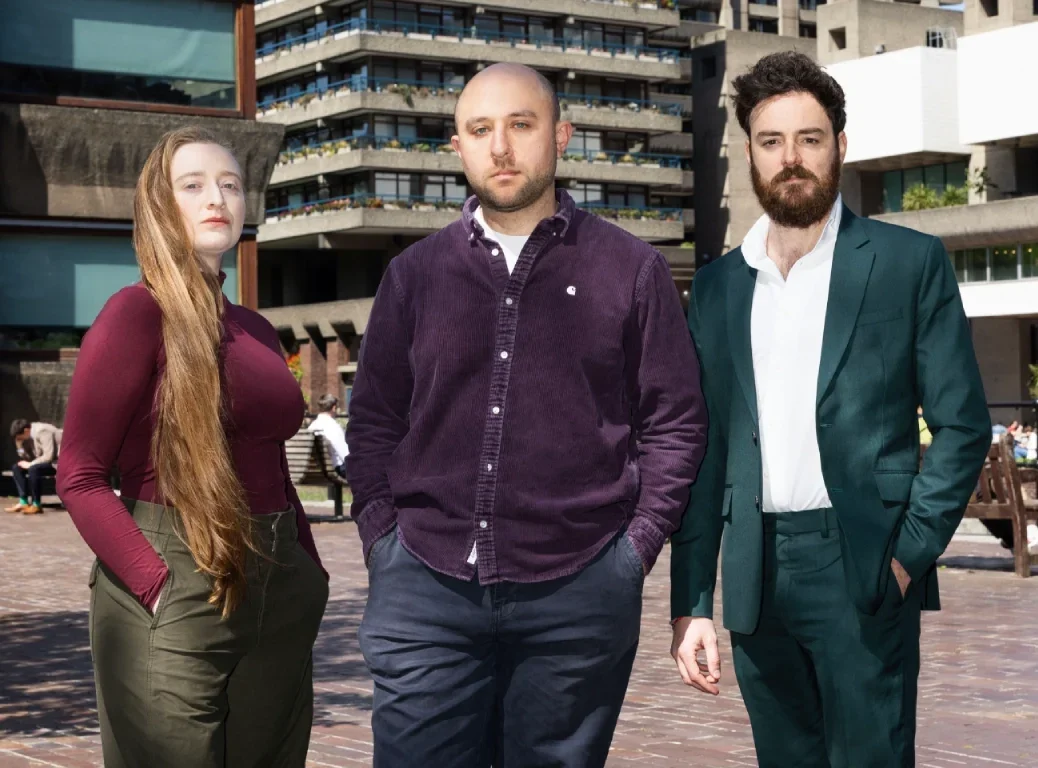New Sunday Times Insight investigations team from left to right: Venetia Menzies, Gabriel Pogrund, and Emanuele Midolo standing side by side in large courtyard with buildings behind