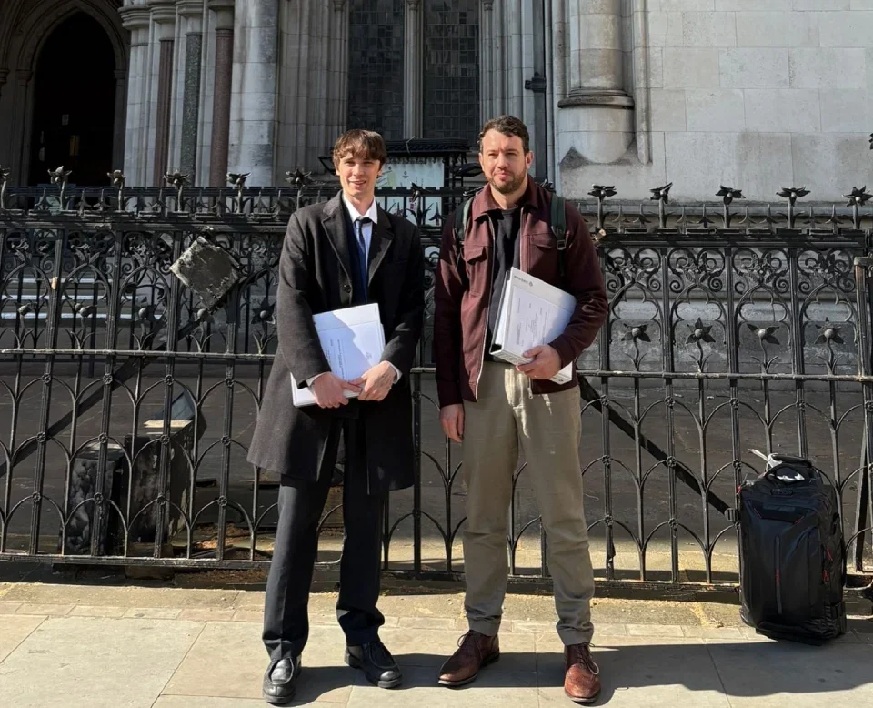 Freelance journalist Cormac Kehoe and Mill Media founder Joshi Herrmann stand next to each other smiling outside the Royal Courts of Justice in London