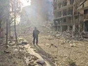 Destruction in the Dahyeh suburb of Beiruit, Lebanon with one man standing in silhouette in middle of rubble