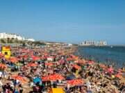 Crowds on the beach during a heatwave in Brighton, UK. Melanie Hobson / Shutterstock.com