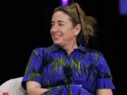 Guardian editor-in-chief Katharine Viner speaking at WAN-IFRA World News Media Congress smiling at someone off camera and wearing blue dress