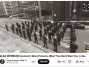 Screenshot of black and white video showing man lined up in columns protest outside Daily Record office