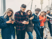 Young people looking at phones. Picture: Shutterstock