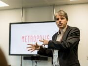 Robert Marr in front of a TV screen with the words 'Metropolis' displayed.