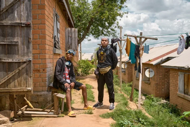 Two young men pose outside a building in Madagascar armed with goggles and gas masks
