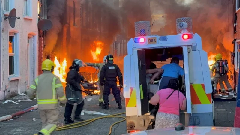 Shortlisted Press Association image in British Journalism Awards 2026 of family being evacuated while homes burn in Belfast riots